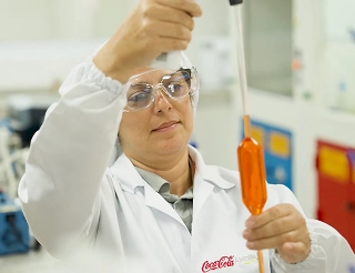 Especialista de laboratorio con equipo de protección utilizando instrumentos de precisión, asegurando la innovación y excelencia en la calidad de cada producto.